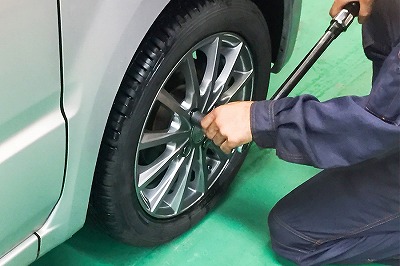 Hands of car mechanic with wrench in garage.